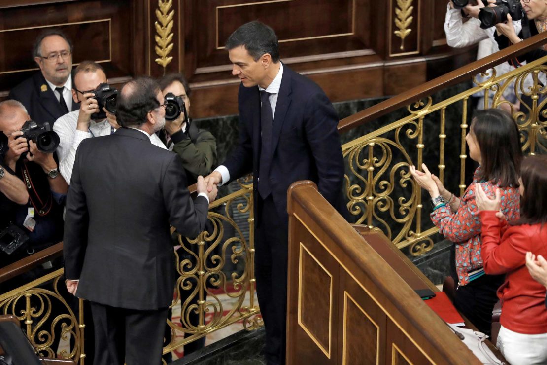 Outgoing Prime Minister Mariano Rajoy, left, shakes hands with Spain's new Prime Minister Pedro Sanchez after the vote.