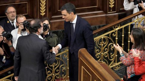 Outgoing Prime Minister Mariano Rajoy, left, shakes hands with Spain's new Prime Minister Pedro Sanchez after the vote.