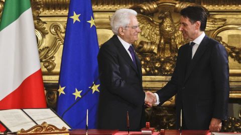 Mattarella (L) shakes hands with Conte during the swearing-in ceremony for Italy's new government Friday.