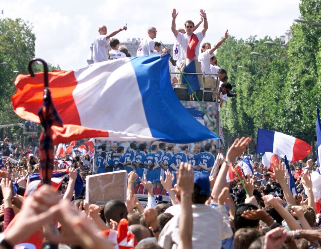 Players of the victorious French national team wave to supporters during a parade on Champs Elysees.