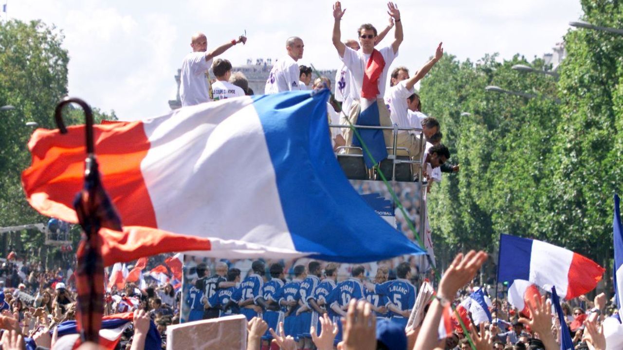 Players of the victorious French national team wave to supporters during a parade on Champs Elysees.