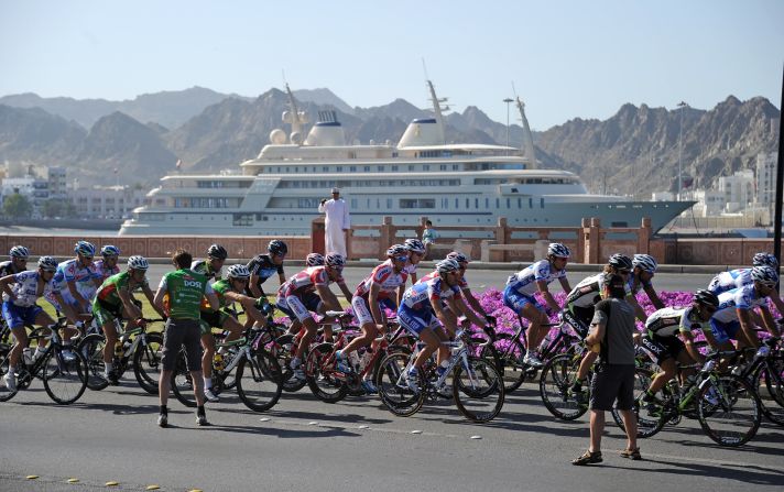Cyclists ride past the Sultan of Oman's yacht  Al Said during the Tour of Oman race in 2011. The superyacht reportedly has space for <a href="index.php?page=&url=http%3A%2F%2Fuk.businessinsider.com%2Fexpensive-luxury-yachts-2018-3%2F%23300-million-the-sultan-of-oman-owns-the-509-foot-long-al-said-yacht-it-has-room-for-more-than-60-guests-and-a-concert-hall-that-can-house-a-50-piece-orchestra-6" target="_blank" target="_blank">a concert hall equipped for a 60-piece orchestra. </a>