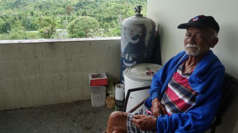Miguel Angel Vera Gonzalez spends much of his day sitting outside his front door and enjoying the views. His Utuado home still doesn't have power