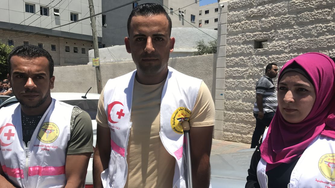 Rami Abu Jazzar, middle, and Rasha Qudeih, right, stand alongside other medical workers protesting outside a UN office in Gaza City.