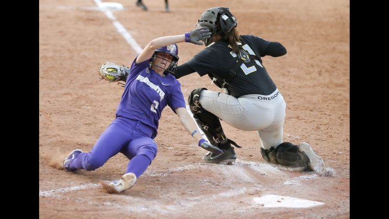 Washington's Trysten Melhart (2) slides home past Oregon's Gwen Svekis (21) during an NCAA softball Women's College World Series game in Oklahoma City, Friday, June 1.