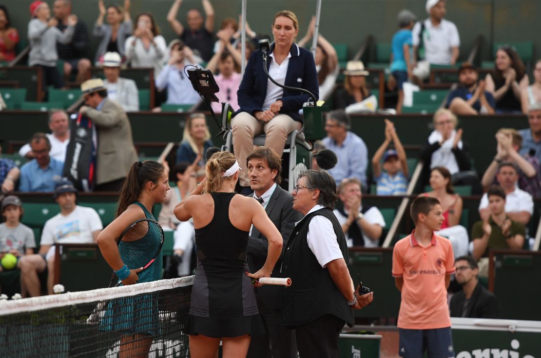 Caroline Wozniacki (right) and Daria Kasatkina talk to French Open officials as light faded in Paris. 