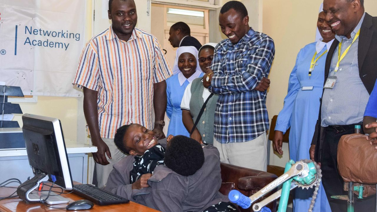 Maria, left, and Consolata Mwakikuti with teaching staff at Ruaha Catholic University.