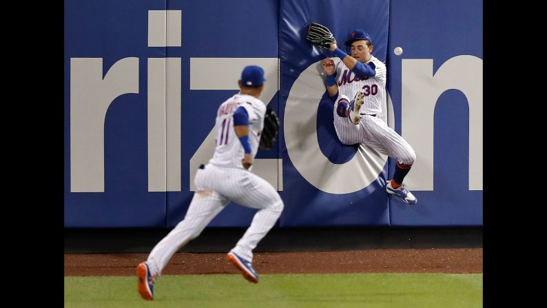 New York Mets center fielder Michael Conforto hits the wall as he attempts to catch the ball during the seventh inning of a baseball game against the Chicago Cubs on Saturday, June 2.