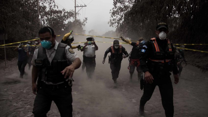 epaselect epa06783851 Guatemalan policemen help people evacuate in the village El Porvenir, Guatemala, 03 June 2018, after the eruption of the Fuego volcano, which has left at least seven people dead, around 20 injured and 1.7 million people affected, according to the Guatemalan authorities.  EPA-EFE/JOSE MISA