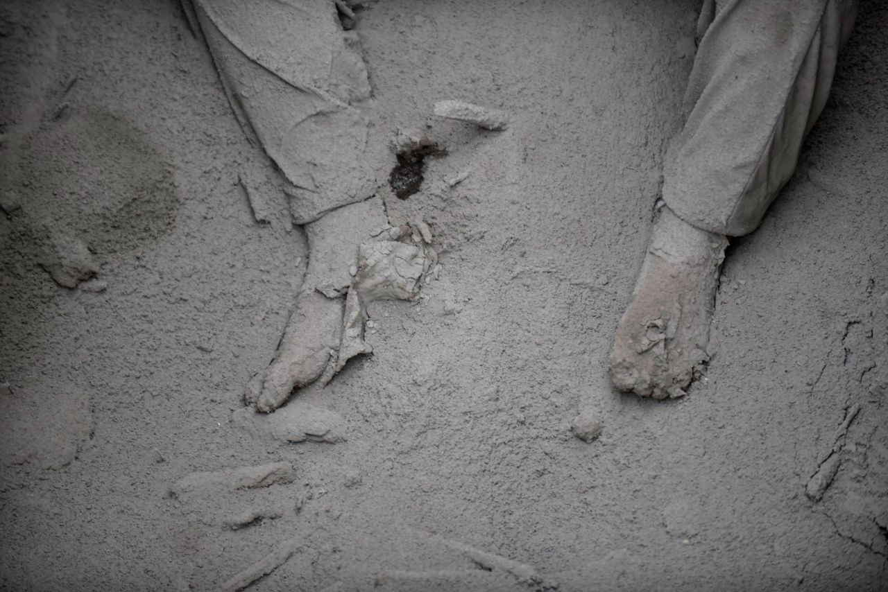 A victim is covered in ash in San Miguel Los Lotes.