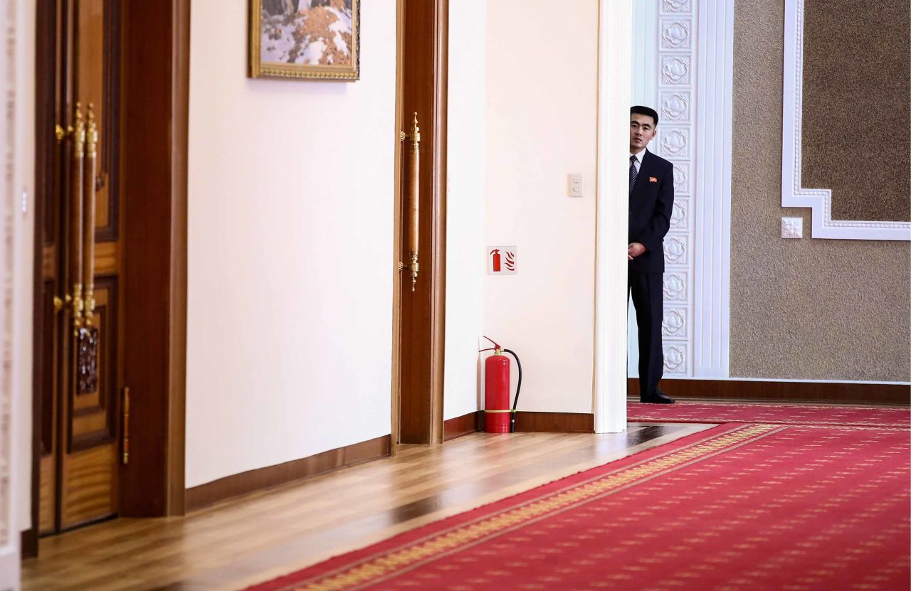 A security guard peers around a corner during Lavrov and Kim's meeting at Kumsusan Palace.