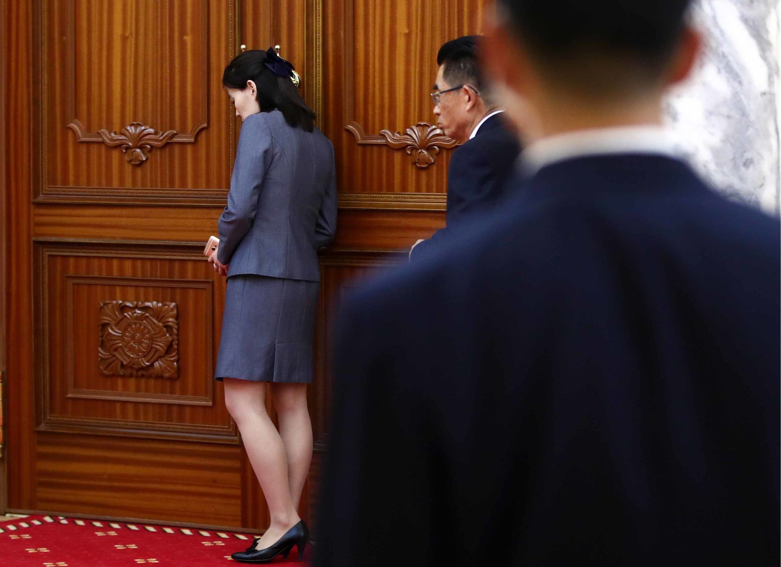 Kim Yo Jong and security guards stand near a door during the meeting of Kim and Lavrov.