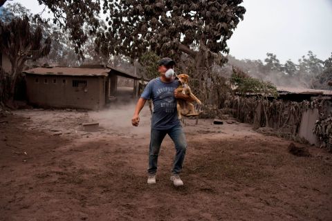 A man carries his dog in San Miguel Los Lotes.