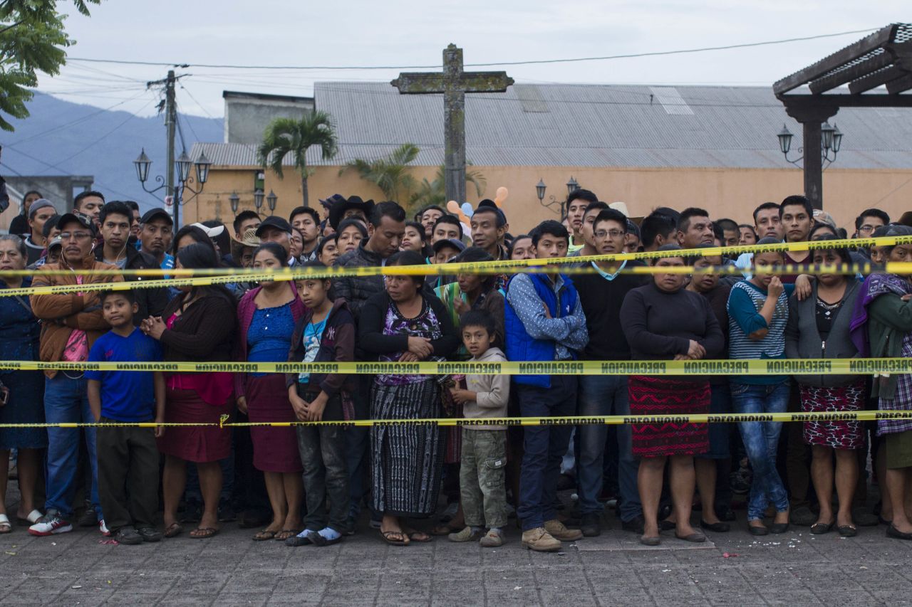 Neighbors stand outside a temporary morgue in Alotenango.
