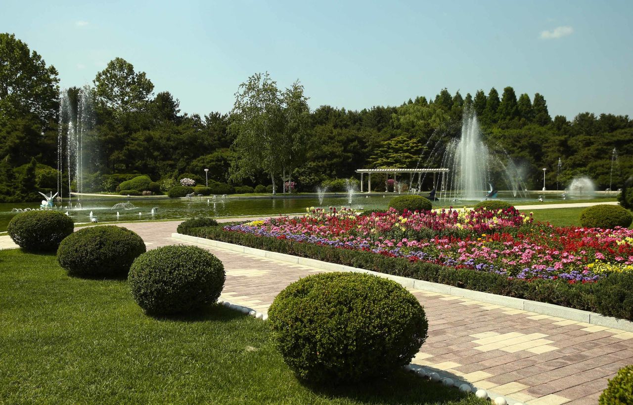 Landscaping and fountains are seen on the grounds of the property.