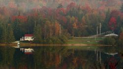 Leaves begin turning color in the early morning mist 06 October 2007 as houses and trees are reflected on Big Pond near Woodford, Vermont. Fall foliage in the New England region is reaching its peak this week.          AFP PHOTO/Stan HONDA (Photo credit should read STAN HONDA/AFP/Getty Images)