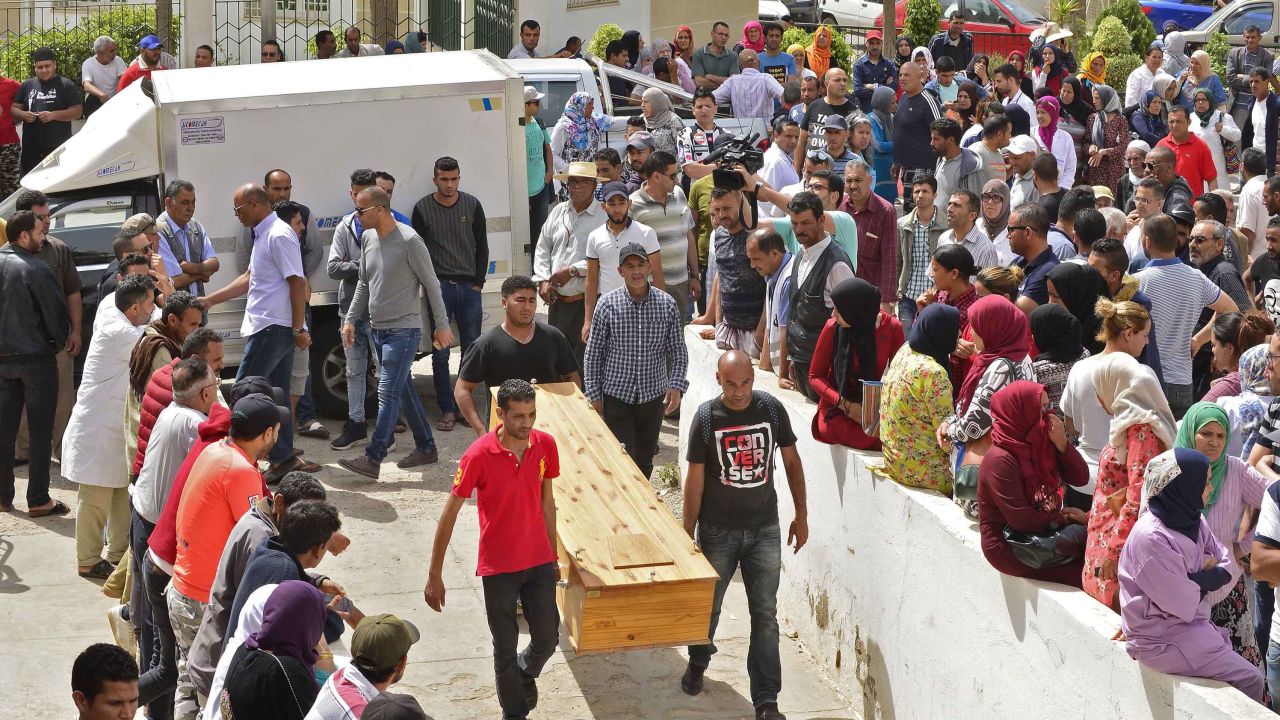 People wait to receive the bodies of loved ones in the Tunisian city of Sfax on Monday.