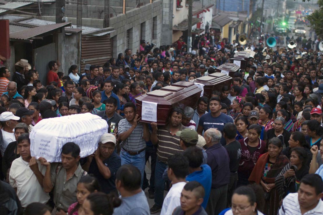 People carry the coffins of  victims of the volcanic eruption in a procession Monday in Alotenango.