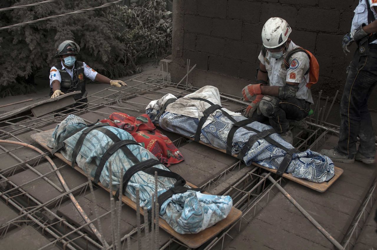 An emergency worker kneels beside bodies recovered in Escuintla on Monday, June 4.