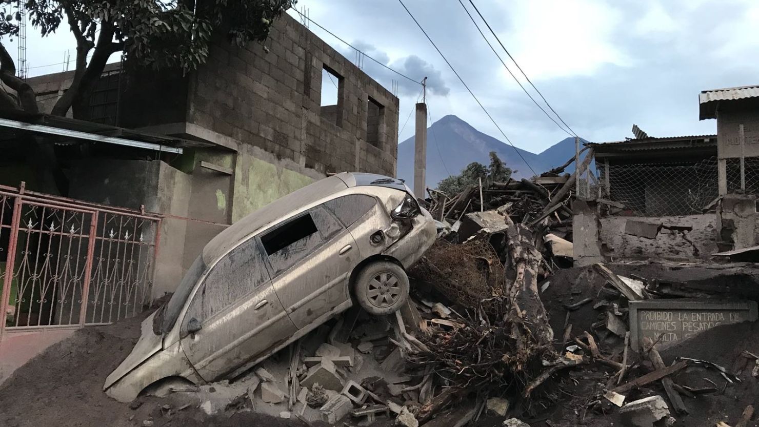 An abandoned car rests atop debris Wednesday in El Rodeo, Guatemala, after the volcano's eruption.