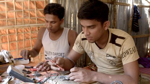 Anowar, right, mends cellphones in Kutupalong refugee camp in Bangladesh.