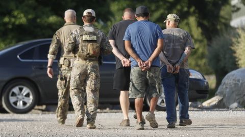 More suspects are taken away during Tuesday's raid at the garden center in Castalia, Ohio.