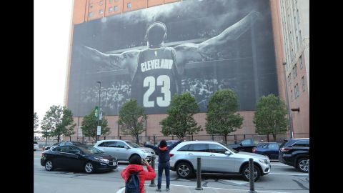 A fan poses in front of a LeBron James mural ahead of Game 3 in Cleveland.