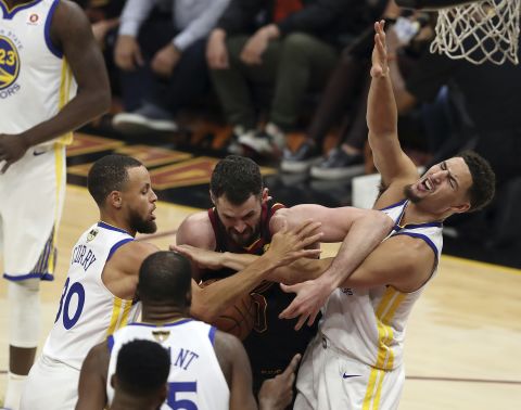 Love is swarmed by Curry, left, and Klay Thompson.
