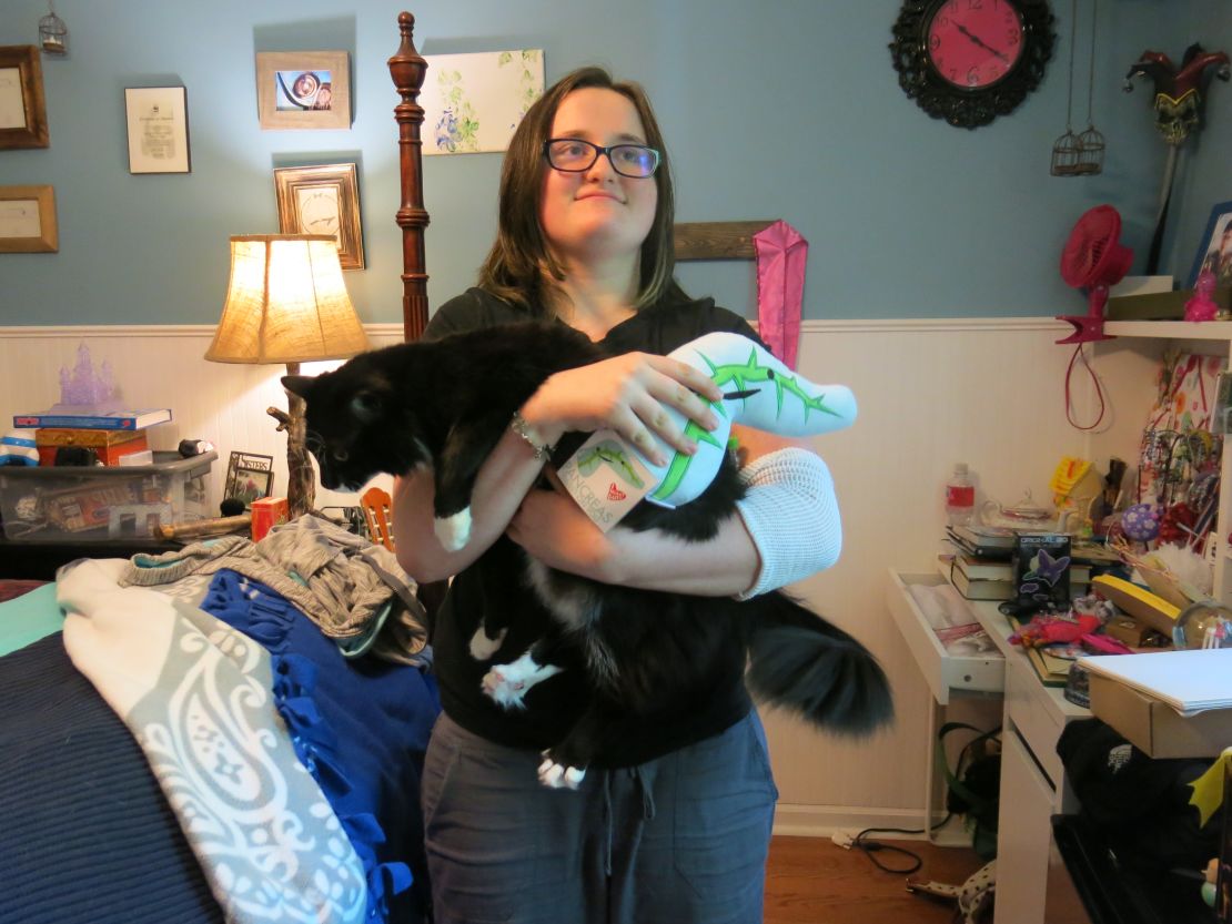 Emmy Reeves holds her cat and a stuffed pancreas. She recently underwent a pancreas transplant that has transformed her life.