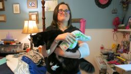 Emmy Reeves holds her cat, Beastly, and a stuffed pancreas. She recently underwent a pancreas transplant that has transformed her life. 