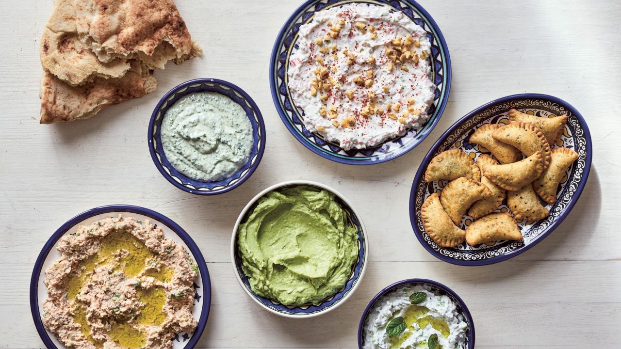 Dips and Small Bites: clockwise from left: Taboon Bread; Parsley or Cilantro (Coriander) Tahini Spread; Walnut and Garlic Labaneh; Deep-Fried Cheese and Za'atar Parcels; Garlic and Cucumber Labaneh; Avocado, Labaneh, and Preserved Lemon Spread; Labaneh And Bulgur Spread. 
