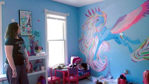 Emmy Reeves shows off the mural she painted in her sister's room after her transplant.