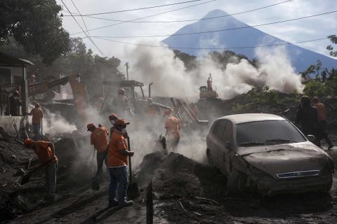 Days after the Fuego volcano erupted, rescue workers remove layers of ash in El Rodeo, Guatemala, on Wednesday, June 6.