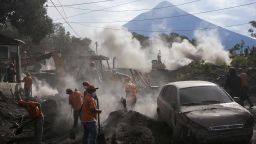 Rescue workers remove piles of ash spewed by the Volcan de Fuego, or "Volcano of Fire," eruption, in El Rodeo, Guatemala, Wednesday, June 6, 2018. Wednesday morning rescuers were concerned about possible dangers posed not only by more volcanic flows but also rain. Authorities have said the window is closing on the chances of finding anyone else alive in the devastation. (AP Photo/Rodrigo Abd)