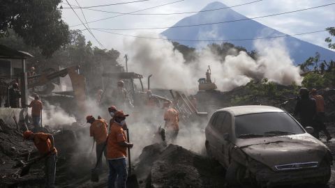 Rescue workers remove piles of ash spewed by the Volcan de Fuego, or "Volcano of Fire," eruption, in El Rodeo, Guatemala, Wednesday, June 6, 2018. Wednesday morning rescuers were concerned about possible dangers posed not only by more volcanic flows but also rain. Authorities have said the window is closing on the chances of finding anyone else alive in the devastation. (AP Photo/Rodrigo Abd)