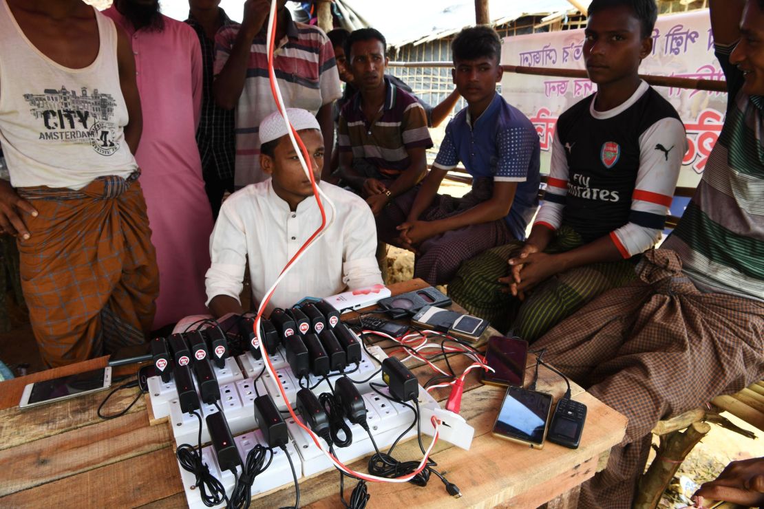 Rohingya refugees wait to get their mobile phones charged at the Kutupalong refugee camp in Bangladesh's Ukhia district on October 7, 2017.

