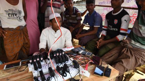 Rohingya refugees wait to get their mobile phones charged at the Kutupalong refugee camp in Bangladesh's Ukhia district on October 7, 2017.