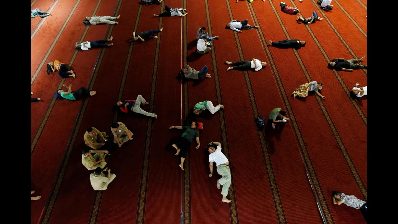 People sleep at a mosque in Jakarta, Indonesia, on Monday, June 4, as they wait for iftar, the sundown meal that breaks fast during the holy month of Ramadan. During Ramadan, Muslims fast from dawn until dusk.