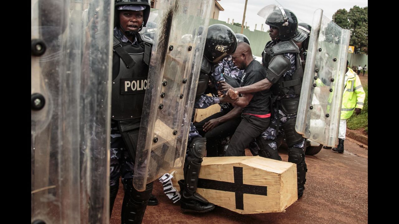 Police officers scuffle with an activist carrying a mock coffin during a protest in Kampala, Uganda, on Tuesday, June 5. Activists are protesting a spate of kidnappings and murders in the country <a href="https://www.cnn.com/2018/06/06/africa/ugandan-activists-parliament-coffin/index.html" target="_blank">by dumping coffins outside the country's parliament building.</a>