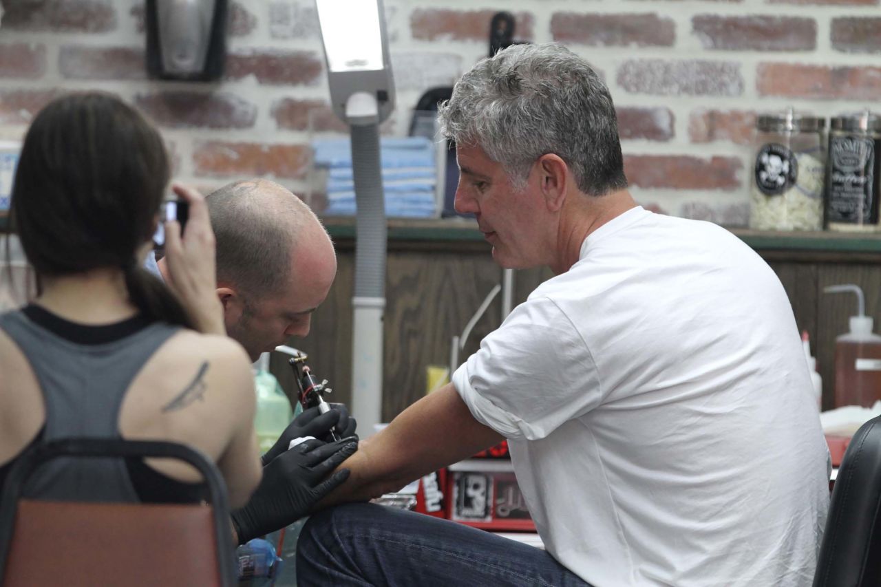 Bourdain and his second wife, Ottavia, get matching snake tattoos in South Beach, Florida, in 2011. The two divorced in 2016.