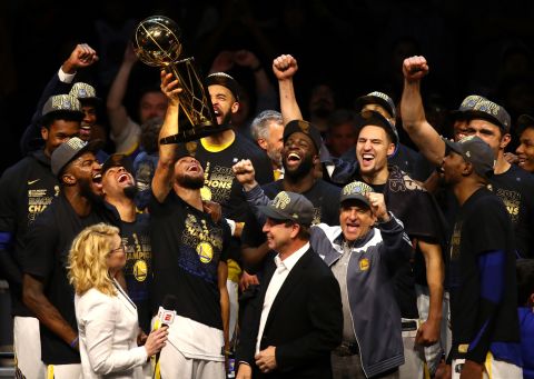 The Golden State Warriors celebrate with the Larry O'Brien Trophy after winning Game 4 of the NBA Finals on Friday, June 8. The Warriors defeated Cleveland 108-85 to complete a series sweep and claim their third title in four years.