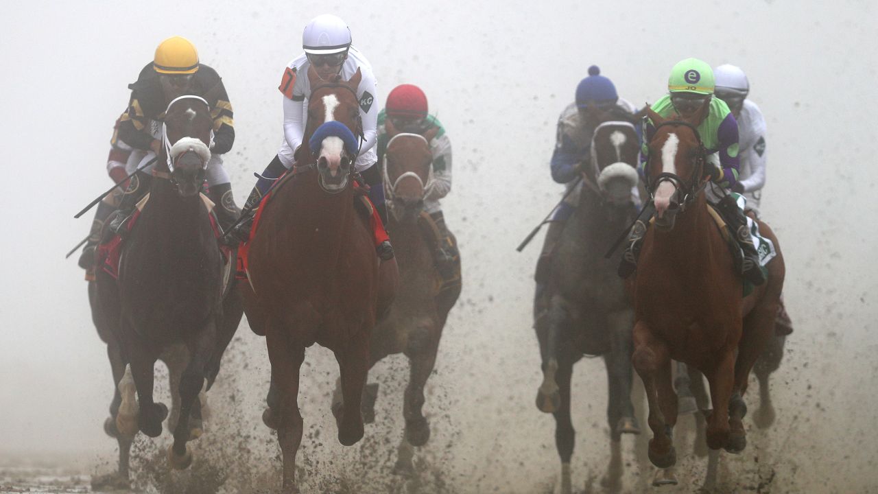Justify (No. 7), ridden by jockey Mike Smith, leads the field into the first turn during the 143rd running of the Preakness Stakes at Pimlico Race Course on May 19, 2018, in Baltimore.