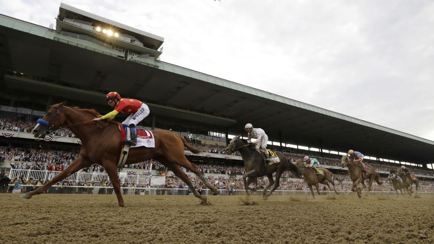 Justify (1), with jockey Mike Smith up, crosses the finish line to win the 150th running of the Belmont Stakes horse race and the Triple Crown, Saturday, June 9, 2018, in Elmont, N.Y. (AP Photo/Julio Cortez)