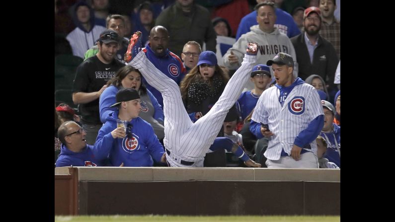 Chicago Cubs second baseman Javier Baez crashes into the seats after making a catch for an out on a ball hit by Philadelphia Phillies' center fielder Odubel Herrera during the ninth inning on Tuesday, June 5 in Chicago. 