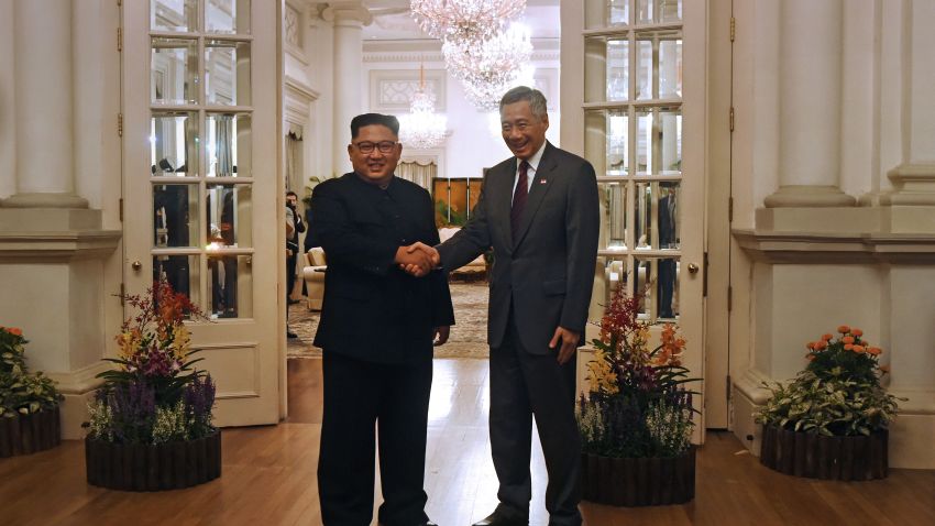 North Korea's leader Kim Jong Un (L) is welcomed by Singapore's Prime Minister Lee Hsien Loong (R) during his visit to The Istana, the official residence of the prime minister, following Kim's arrival in Singapore on June 10, 2018. - Kim Jong Un and Donald Trump will meet on June 12 for an unprecedented summit in an attempt to address the last festering legacy of the Cold War, with the US president calling it a "one time shot" at peace. (Photo by ROSLAN RAHMAN / AFP)     