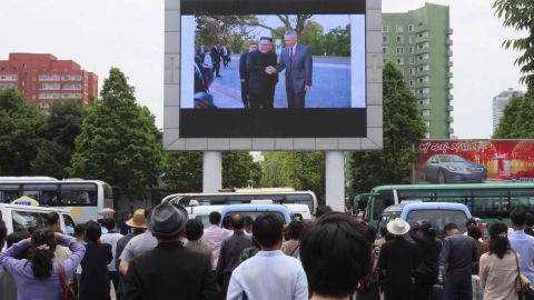 People watch video of Kim Jong Un's arrival in Singapore on a large screen outside Pyongyang's main train station.
