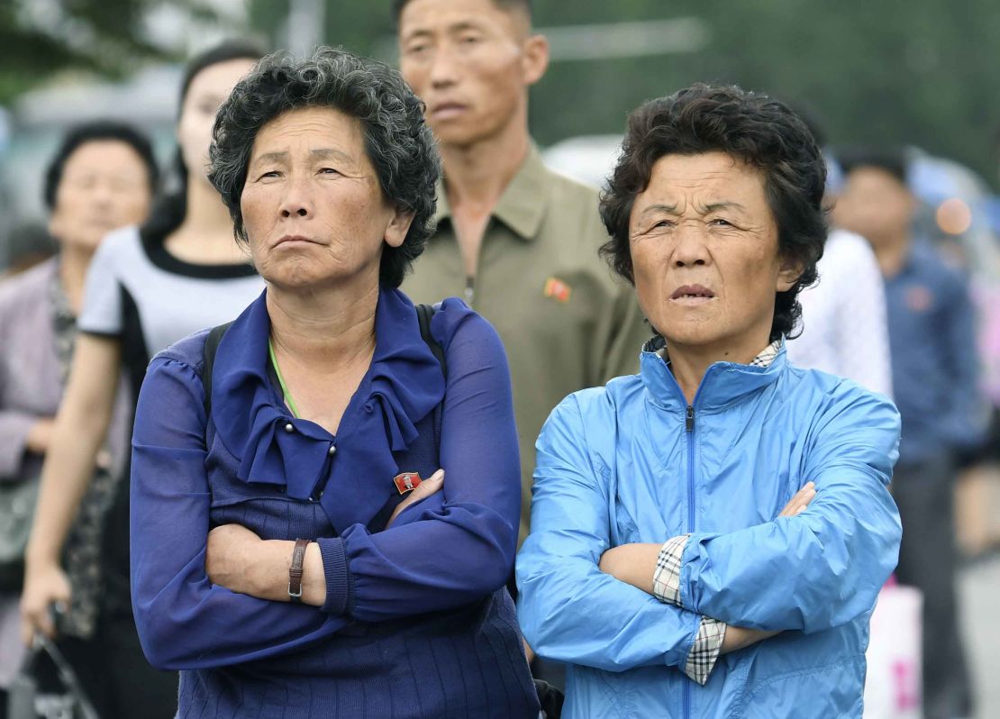 North Koreans look on at a public screen set up near Pyongyang station.