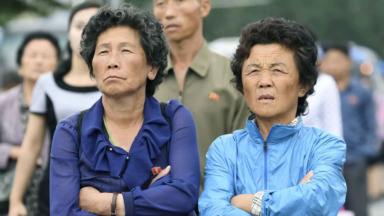 North Koreans look on at a public screen set up near Pyongyang station.