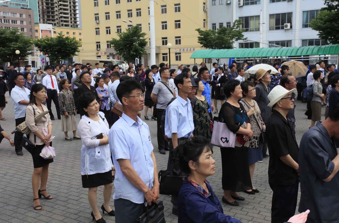 North Koreans in Pyongyang watch a news broadcast of Kim Jong Un's arrival in Singapore.