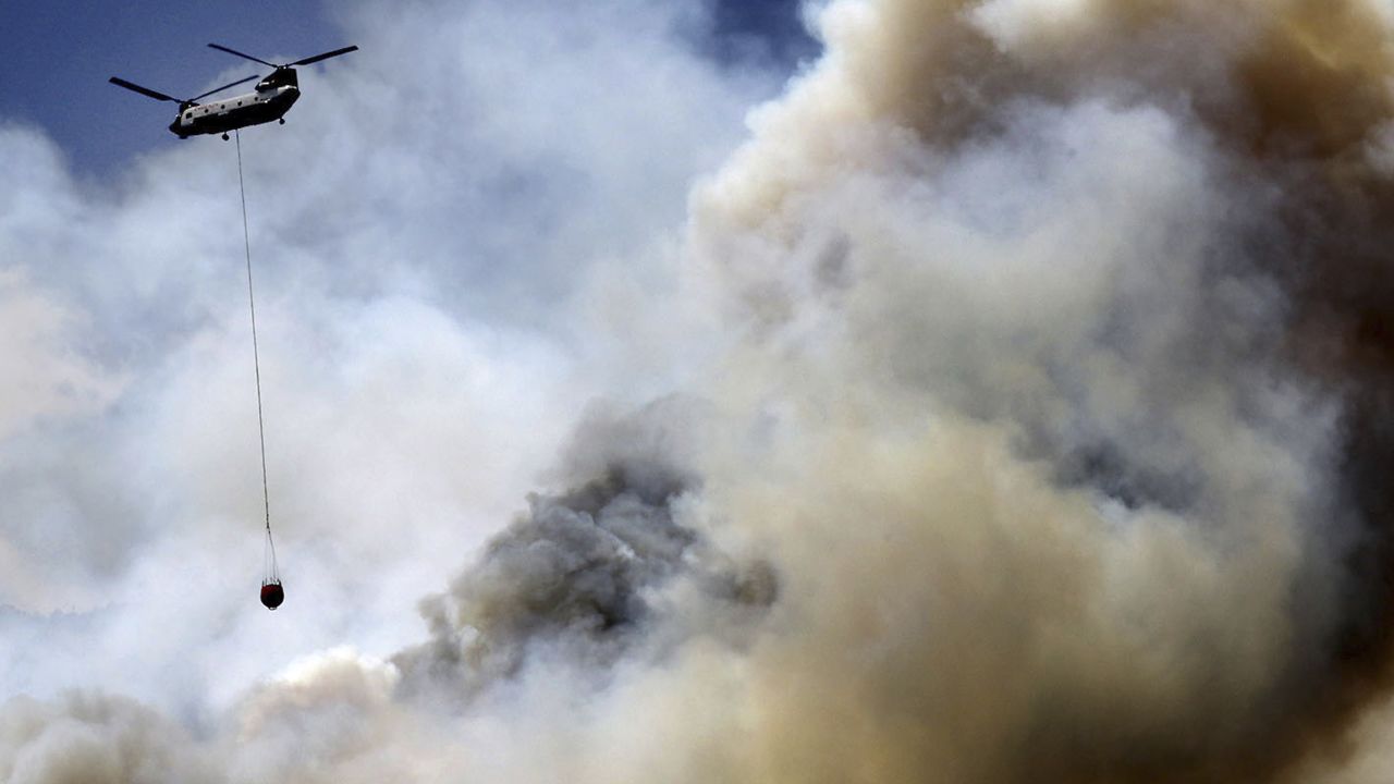 A helicopter works the wildfire on the east side of Hermosa Cliffs near Hermosa, Colorado.